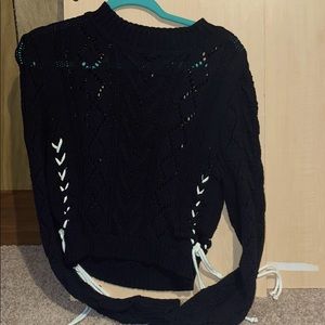 A black sweater with white strings on the side.